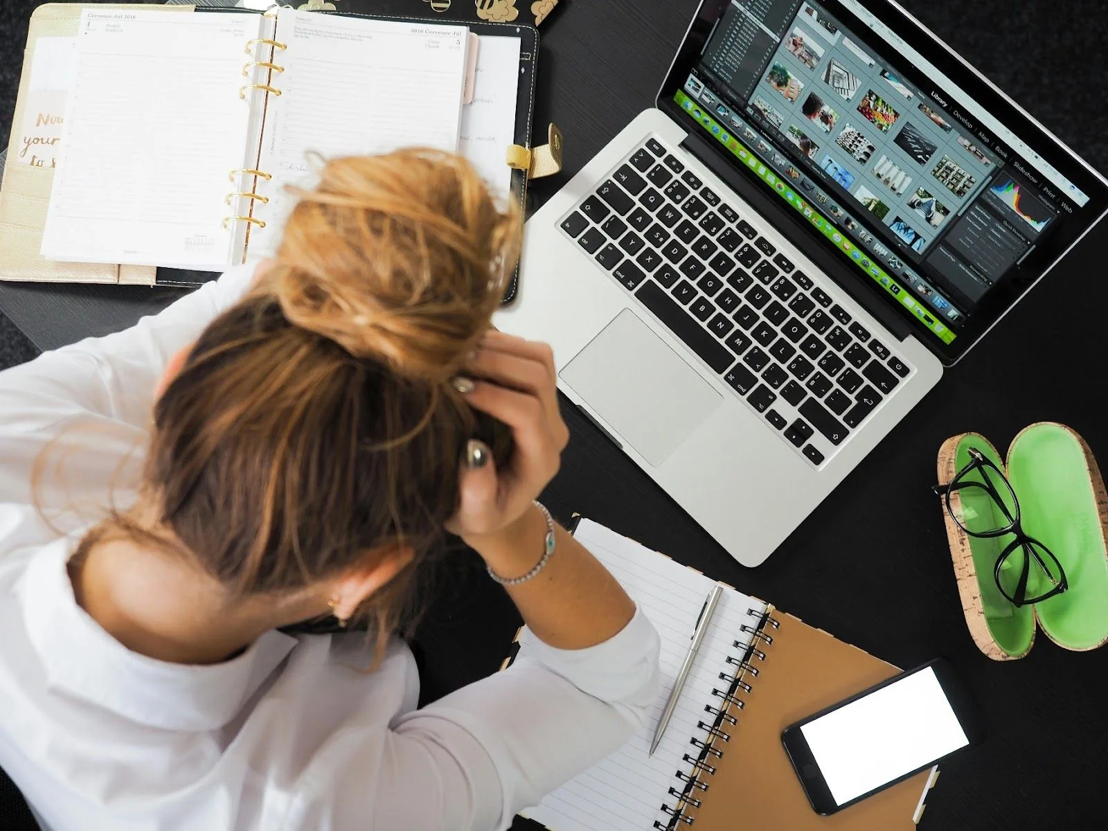 vrouw met handen in het haar voor laptop
